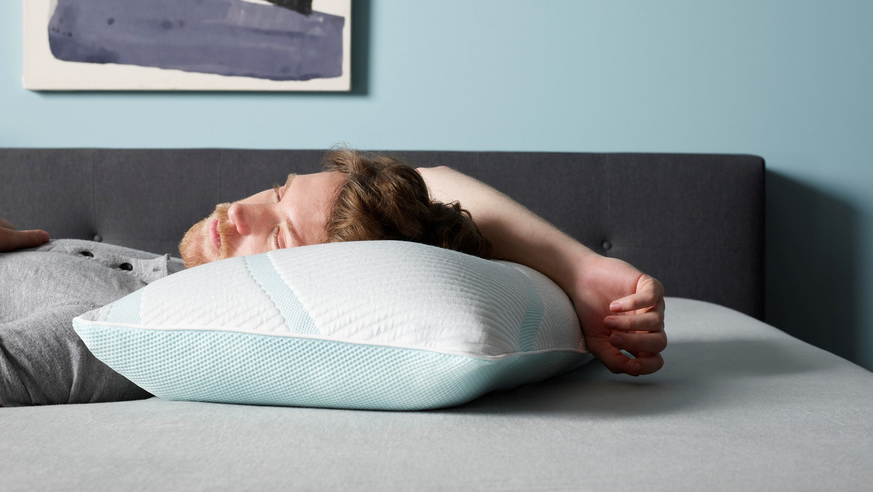 Man laying on a Tempur Pedic bed and pillow