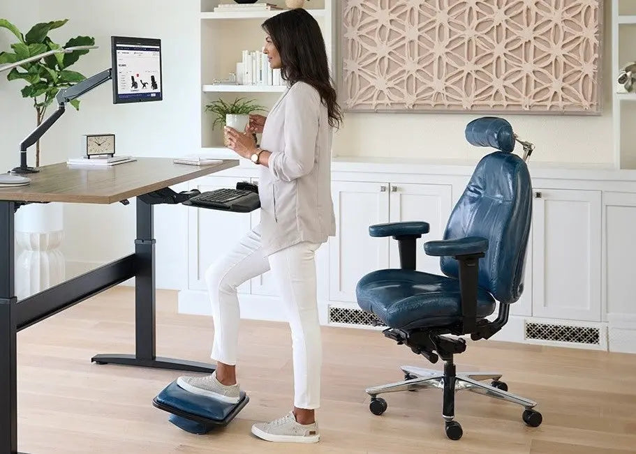 Woman standing at a desk with a blue chair