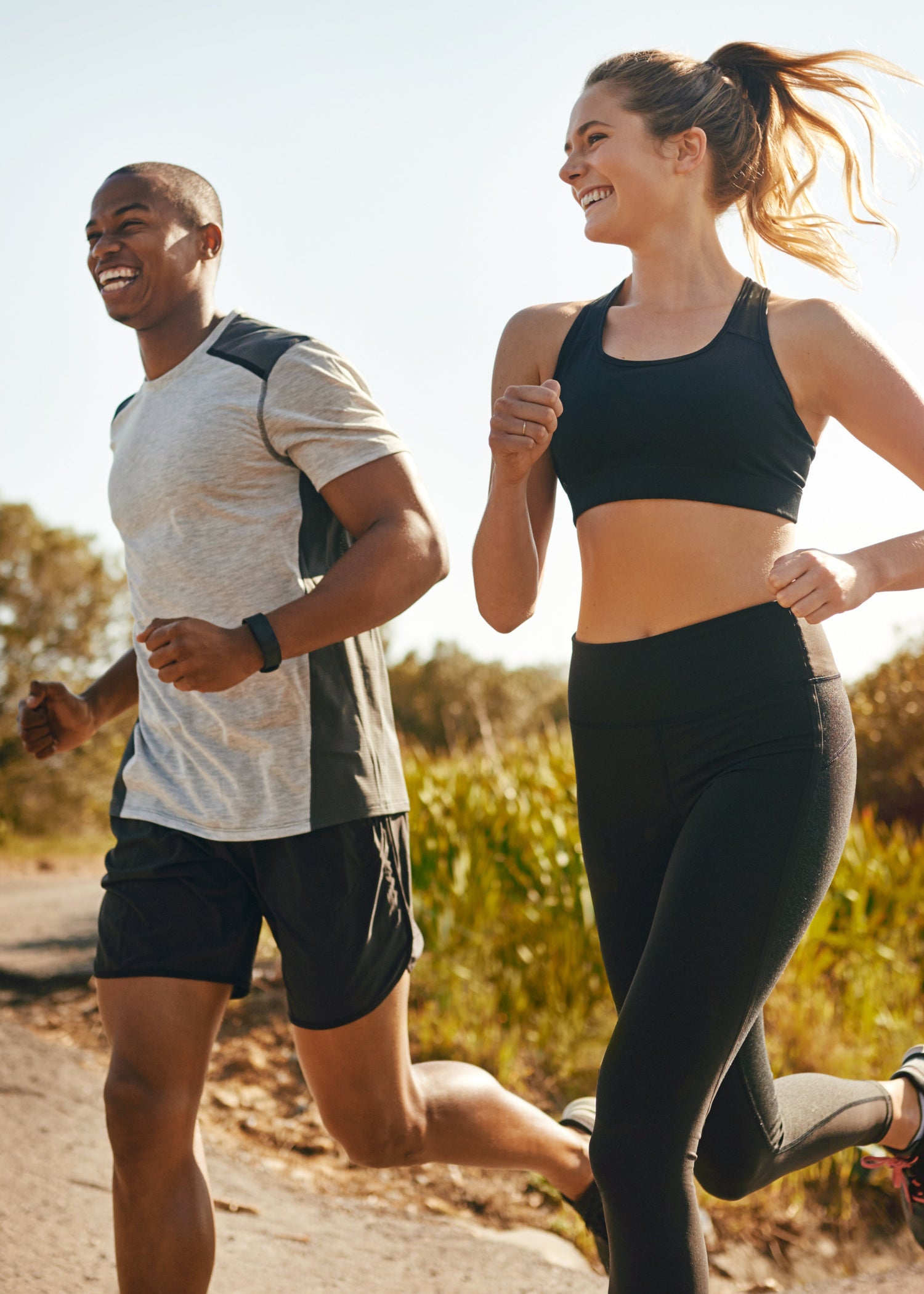 Two people jogging outdoors on a sunny day