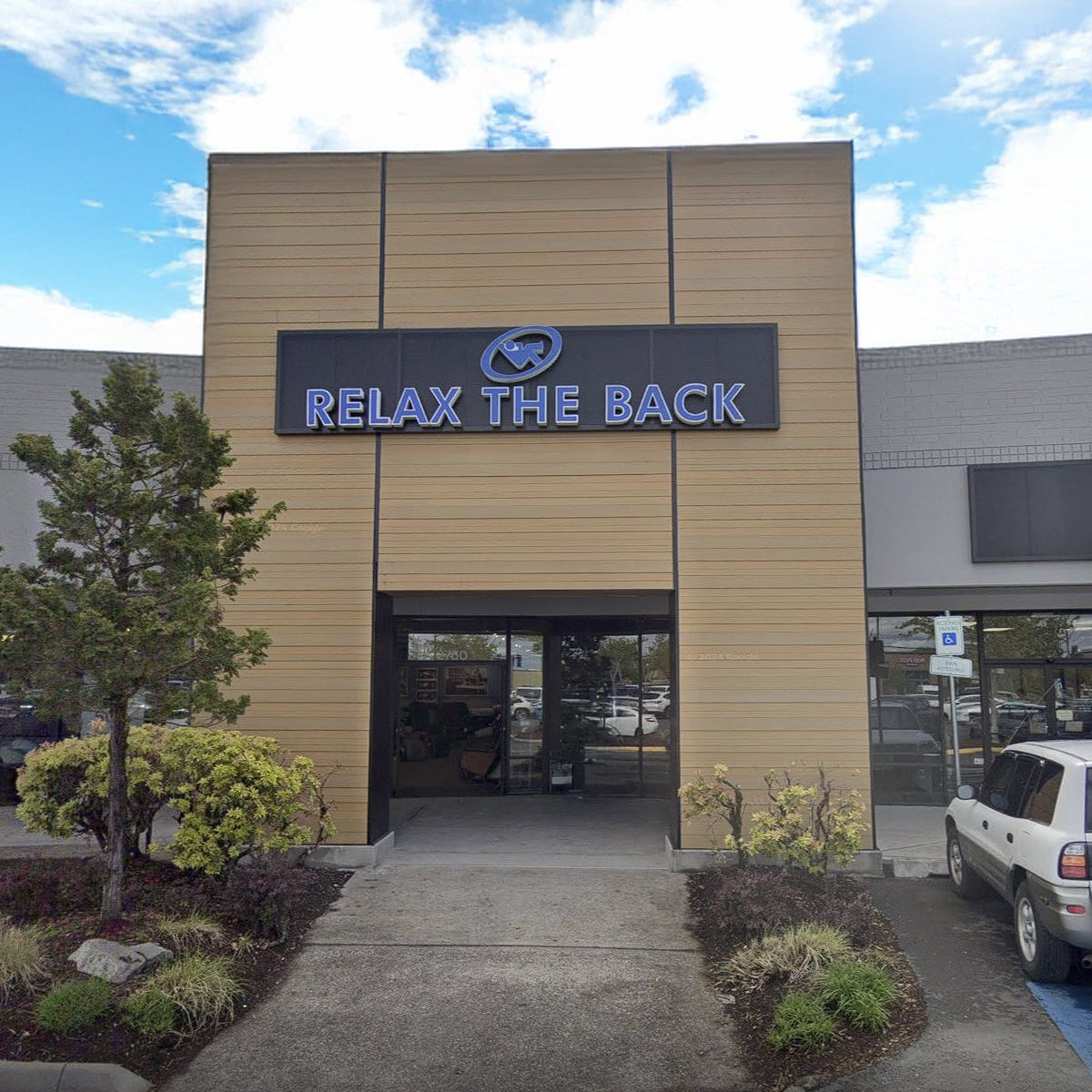 Building exterior with 'Relax the Back' sign on a clear day