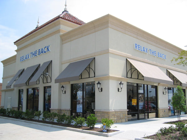 Storefront with 'Relax the Back' branding on a clear day
