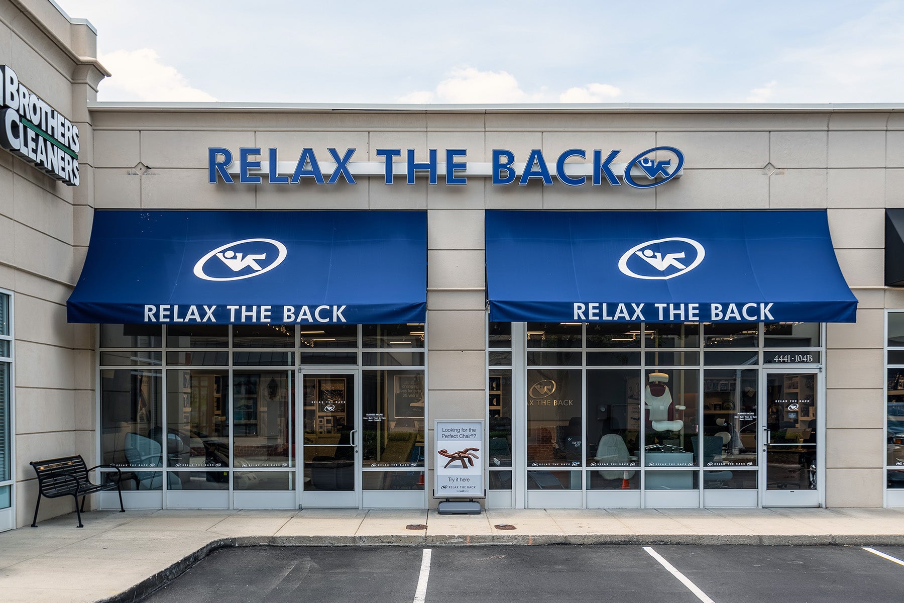 Storefront of 'Relax the Back' with blue awnings and signage.