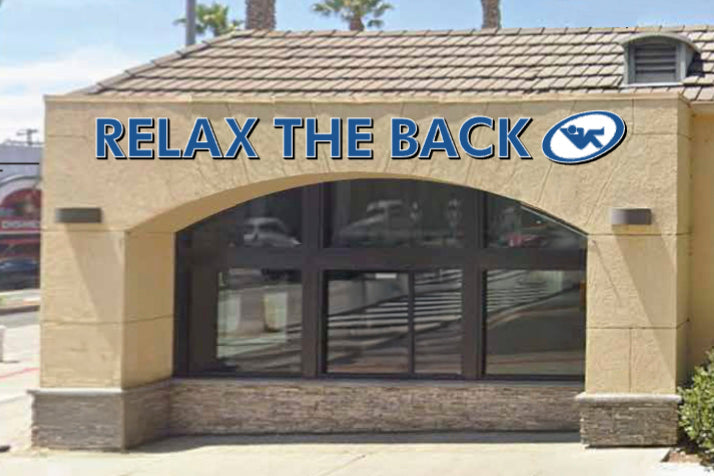 Building with 'Relax the Back' sign and logo on a clear day