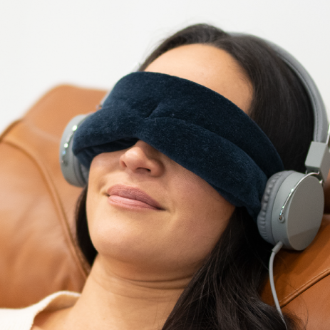 Woman wearing eye mask and listening to meditation