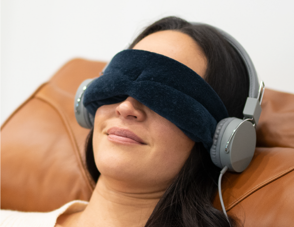 Woman wearing eye mask and listening to meditation