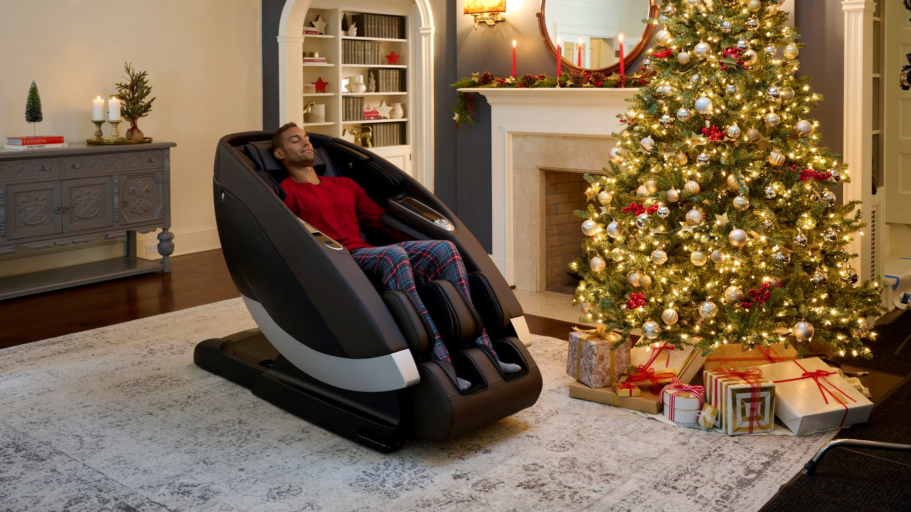Man using the Human Touch Super Novo Massage Chair in a home with a Christmas Tree in the background