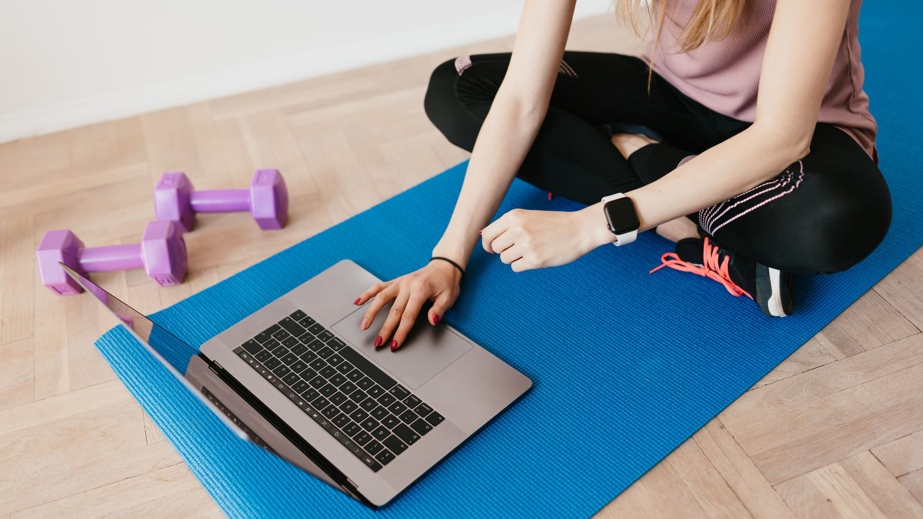 Woman using an Apple Macbook laptop while working out