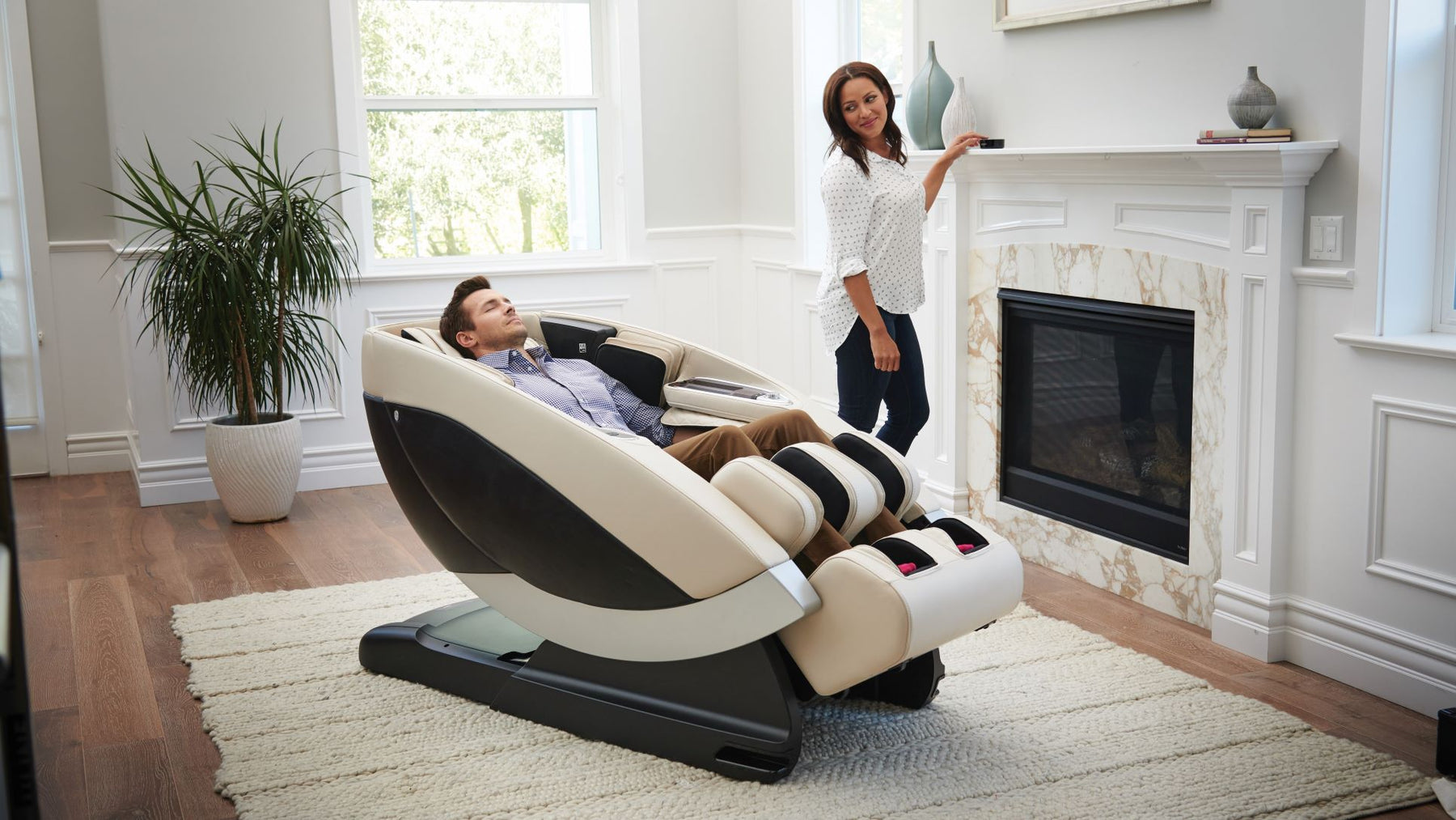 Man using a Human Touch Massage Chair and woman standing by him