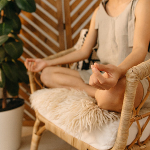 Woman meditating while sitting on a chair