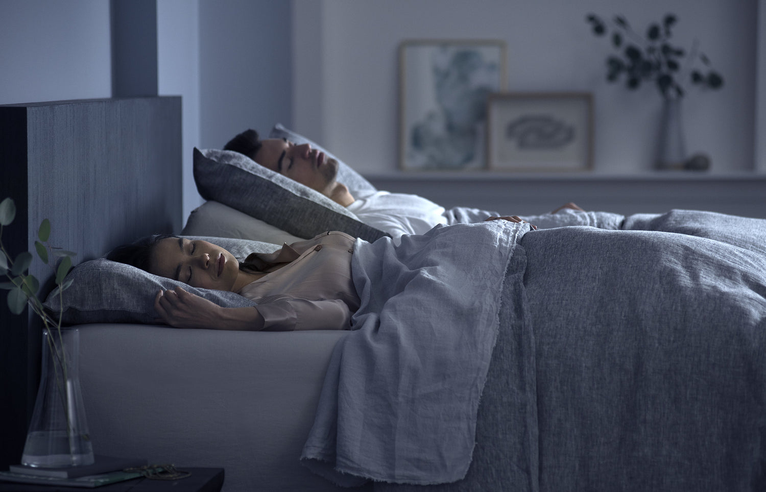 Two people sleeping in a bedroom with a night light on.