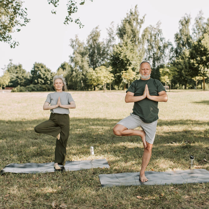 Couple practicing yoga in a park