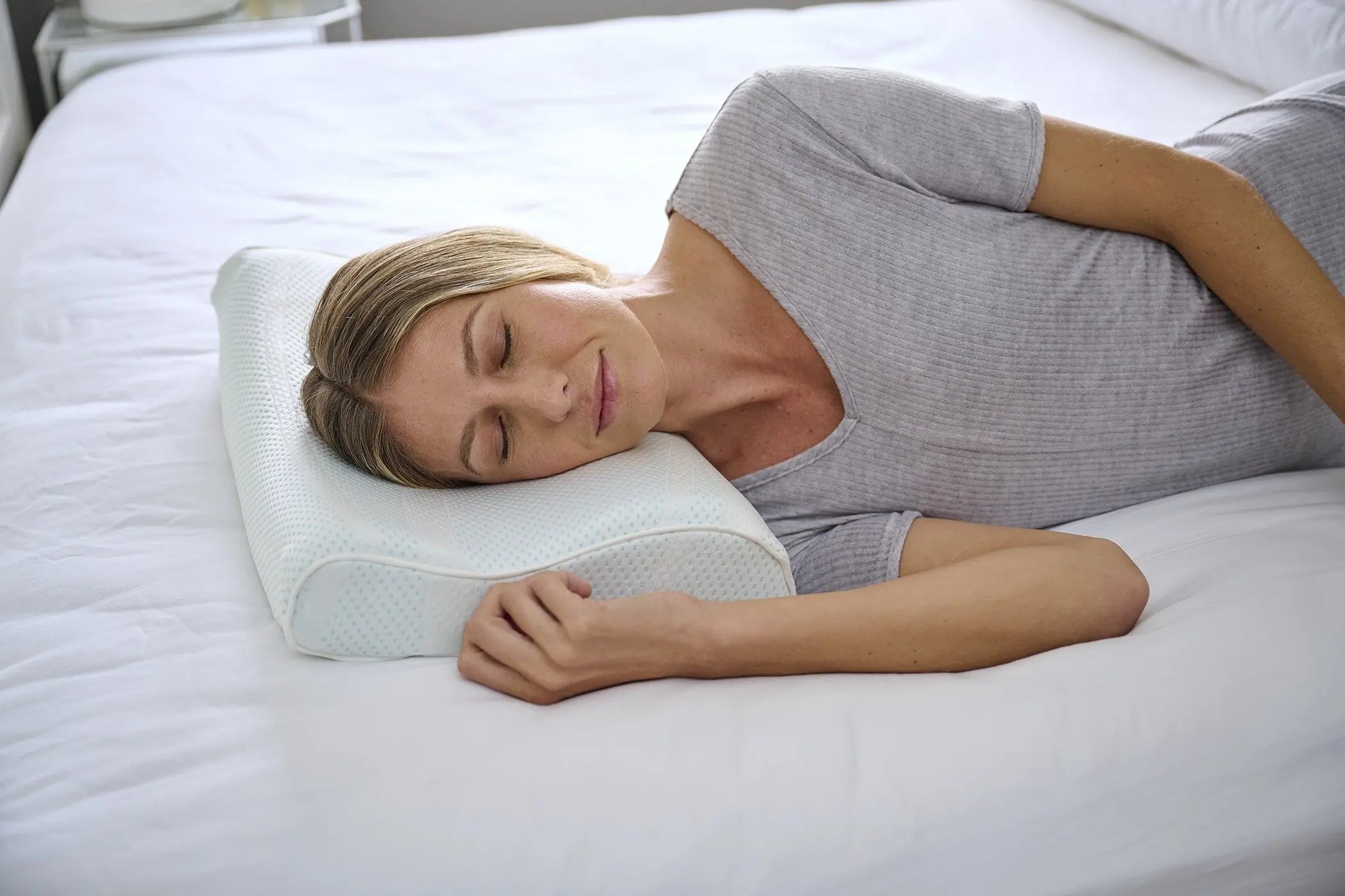 Woman laying on her side using a neck pillow