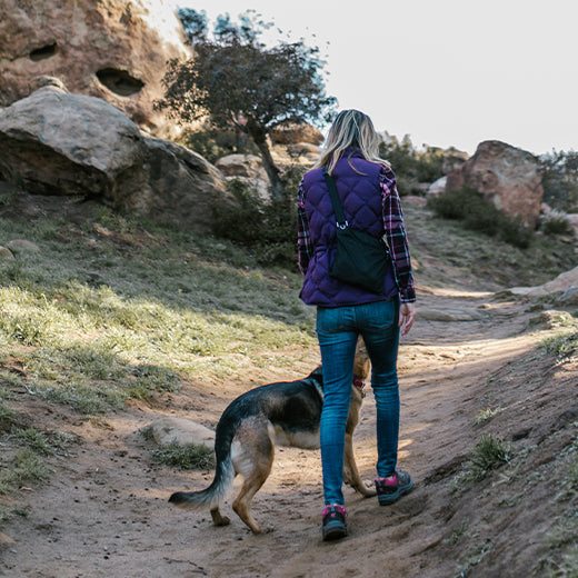 A woman hiking with her dog