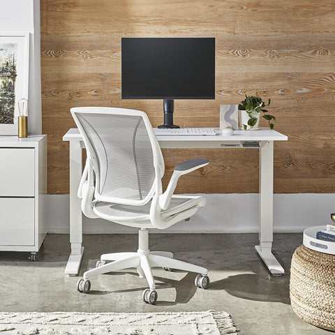 An image of a Humanscale eFloat standing desk and ergonmic office chair.