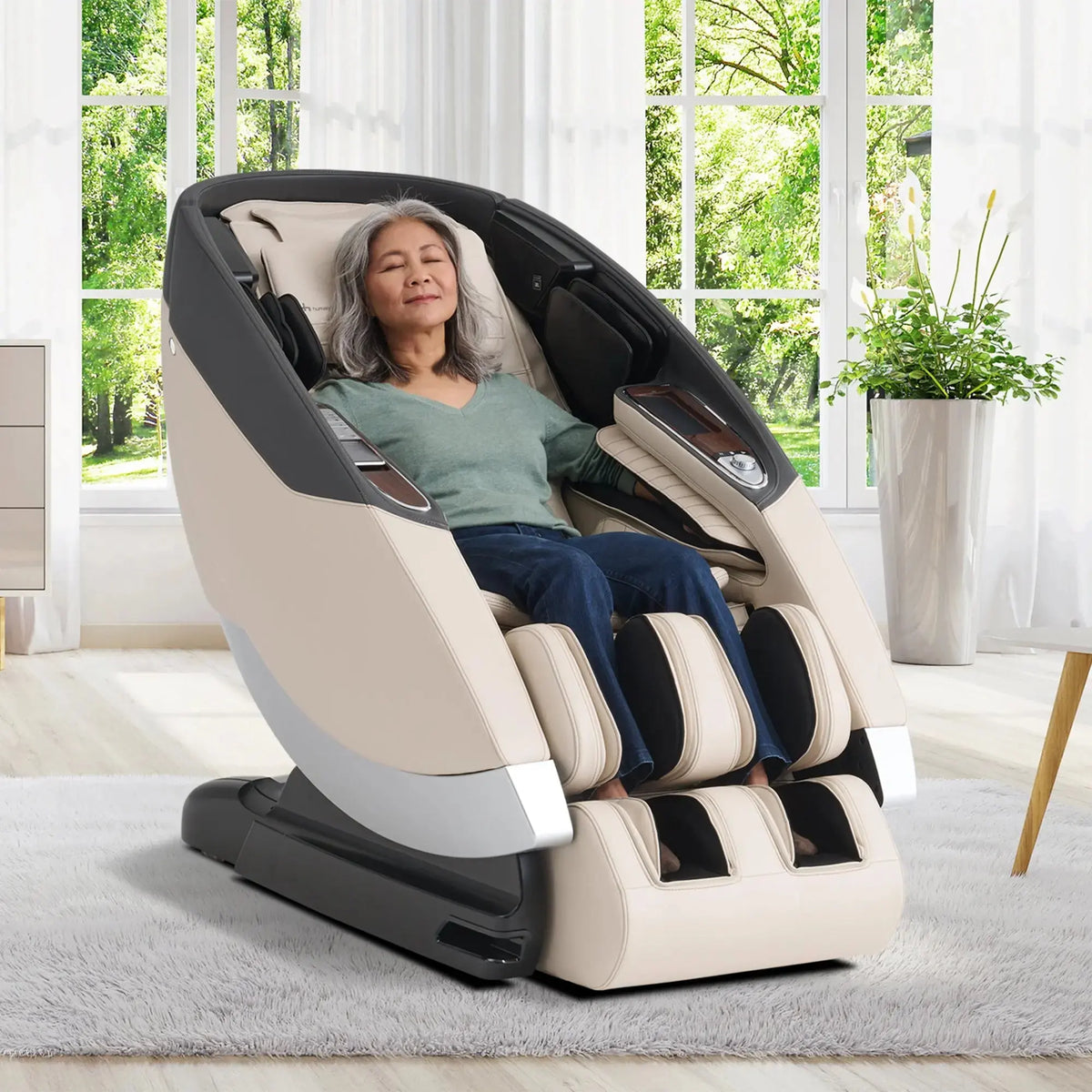 Woman relaxing in a massage chair in a bright room with large windows.