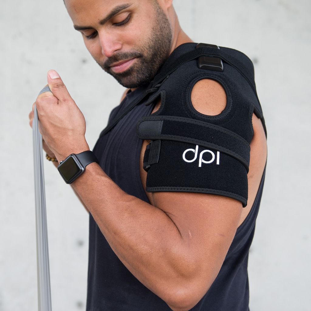 Man wearing a black shoulder brace with 'dpi' logo on a light gray background