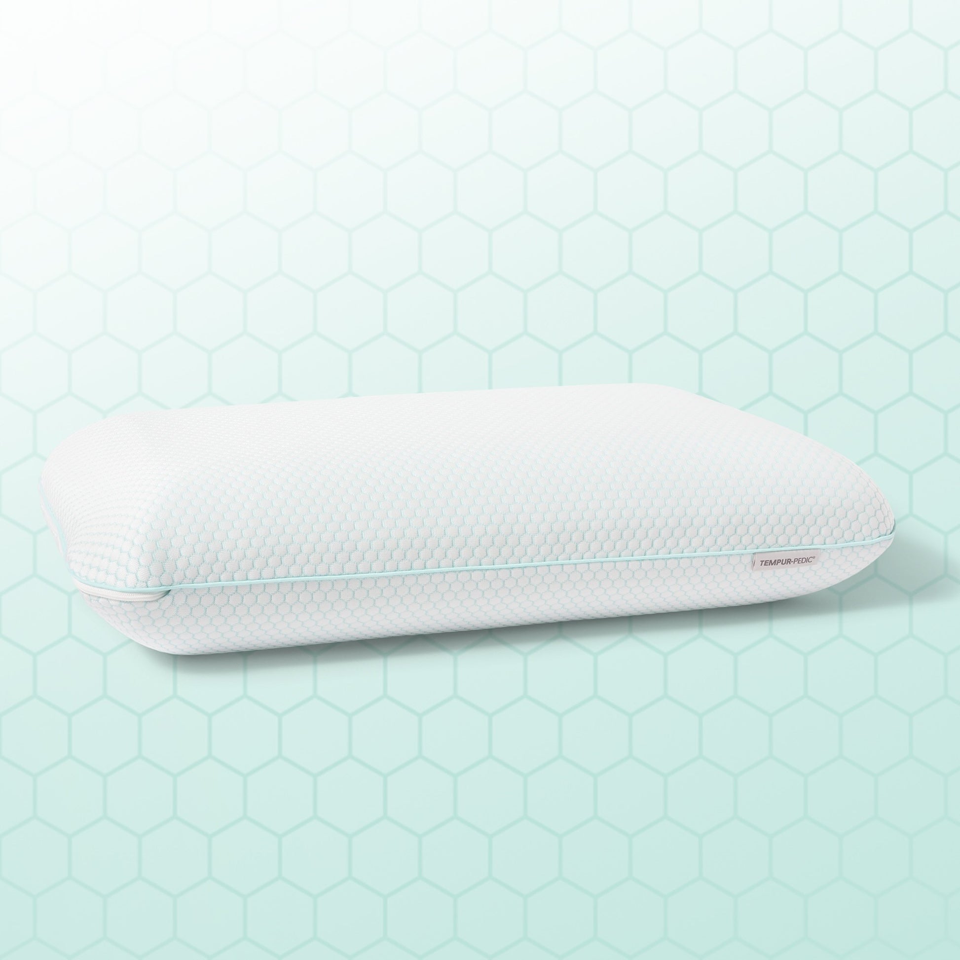 White pillow with a textured surface on a light green hexagonal patterned background