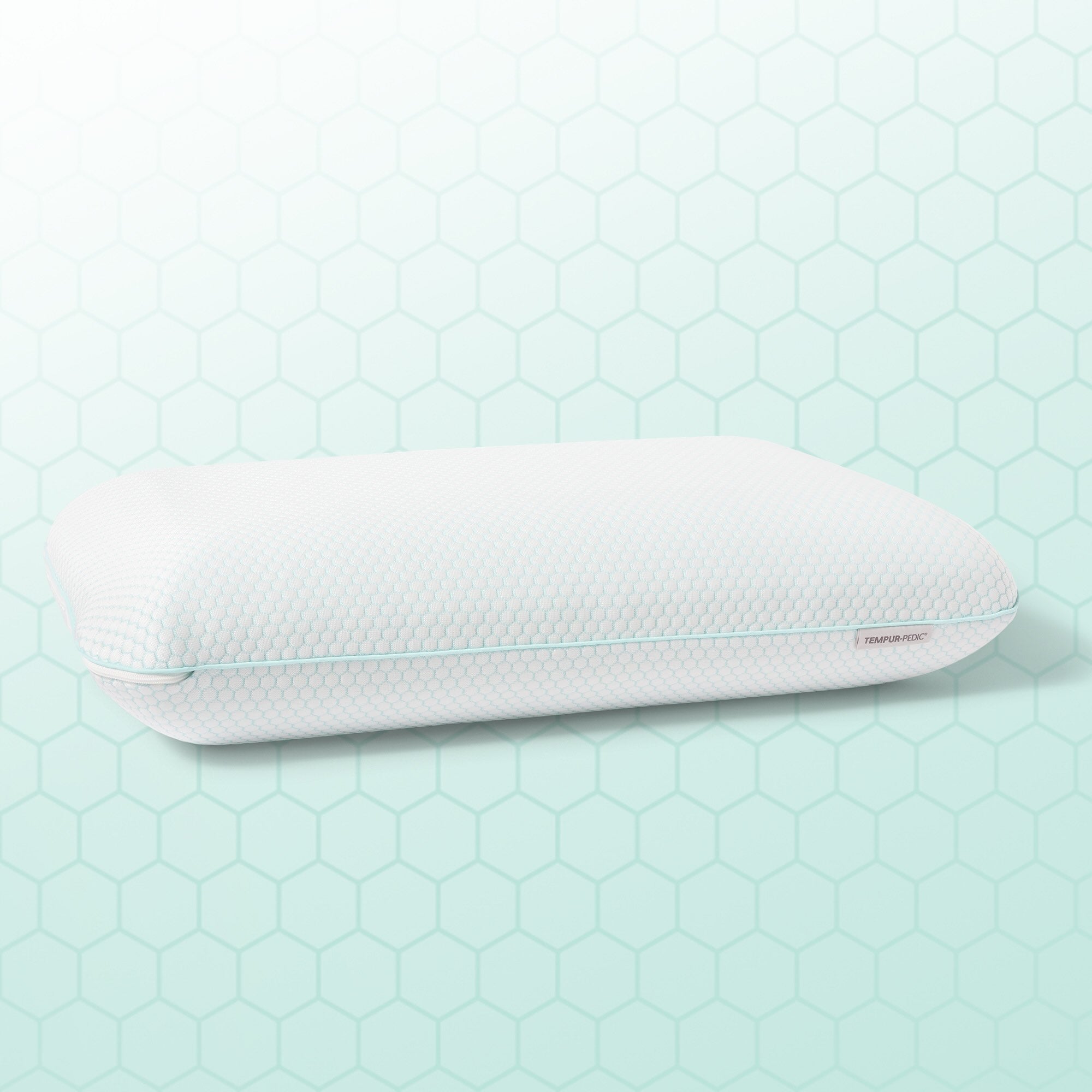 White pillow with a textured surface on a light green hexagonal patterned background