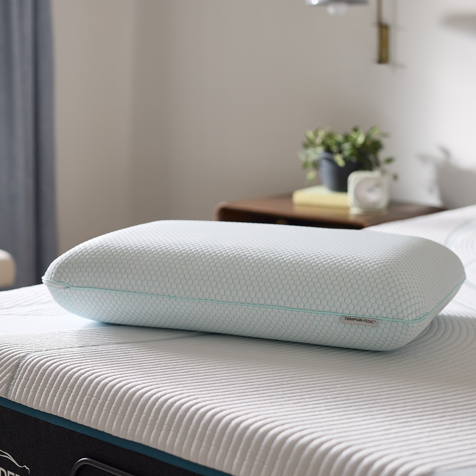 Ergonomic pillow on a bed with a blurred bedroom background