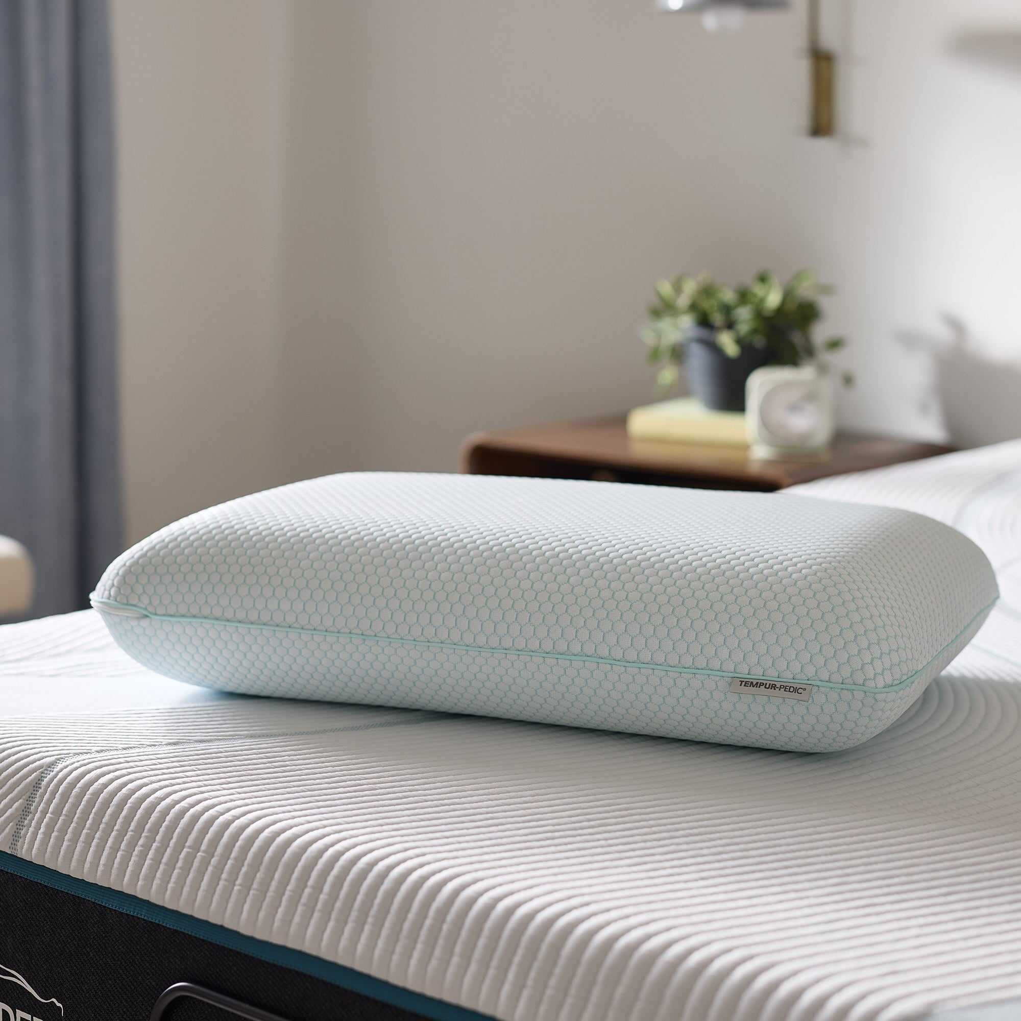 Ergonomic pillow on a bed with a blurred bedroom background