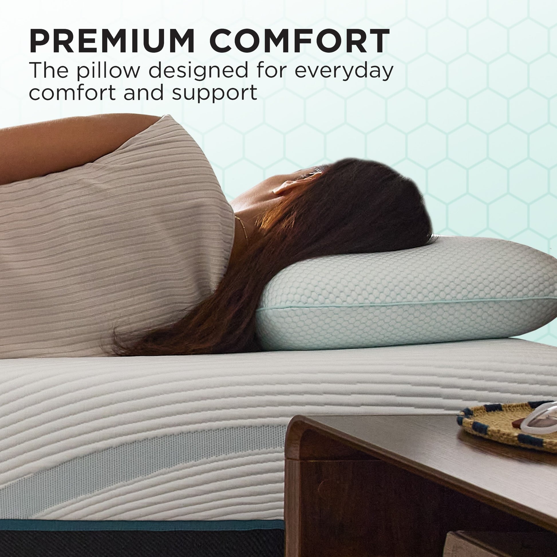 Woman lying on a bed with two pillows, emphasizing comfort and support.