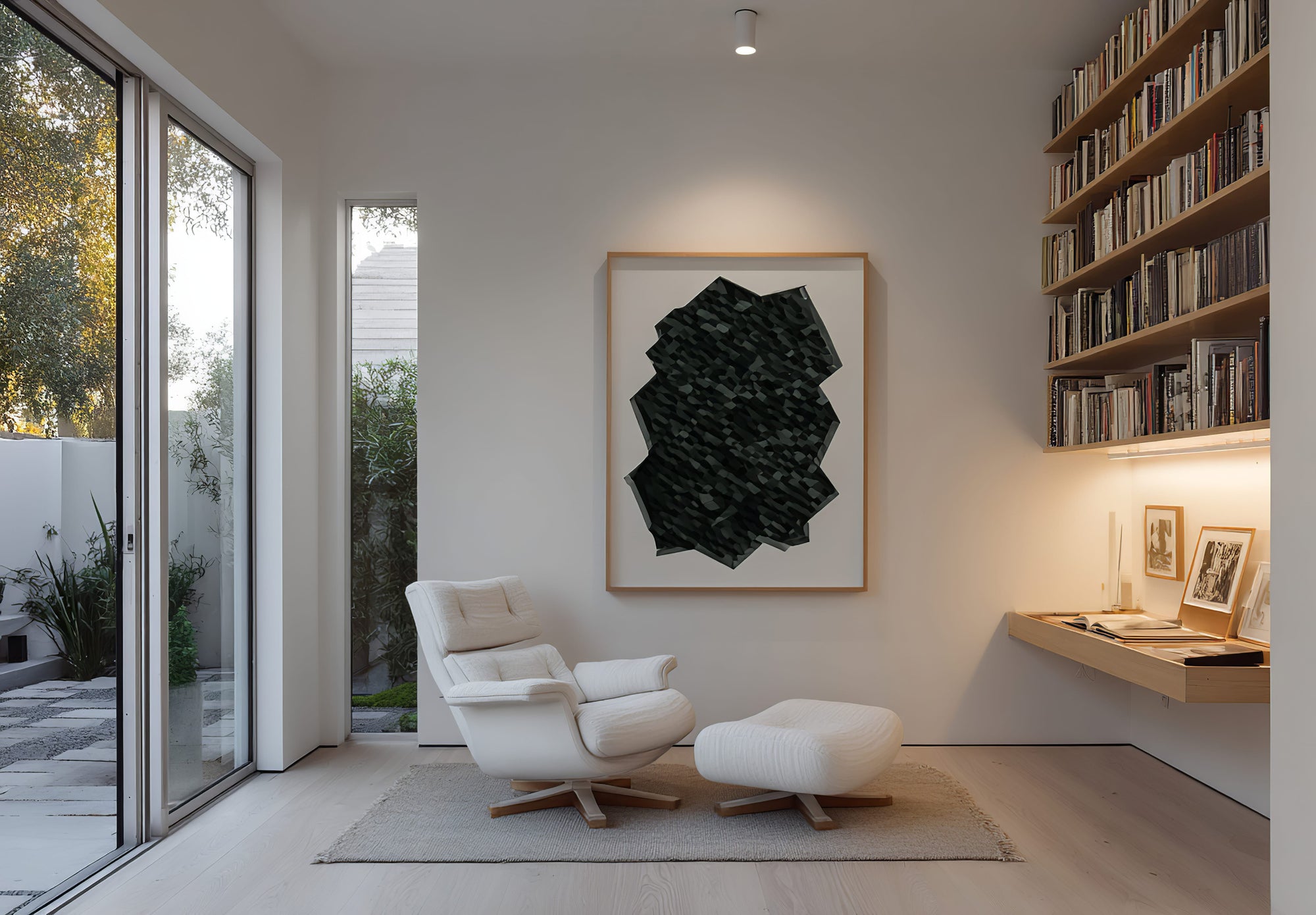 Modern living room with white armchair, ottoman, and abstract art on the wall.