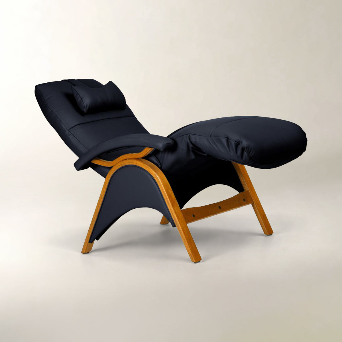 A modern lounge chair with a dark navy blue padded seat, backrest, and headrest, supported by a curved light brown wooden frame, shown against a neutral light beige background.