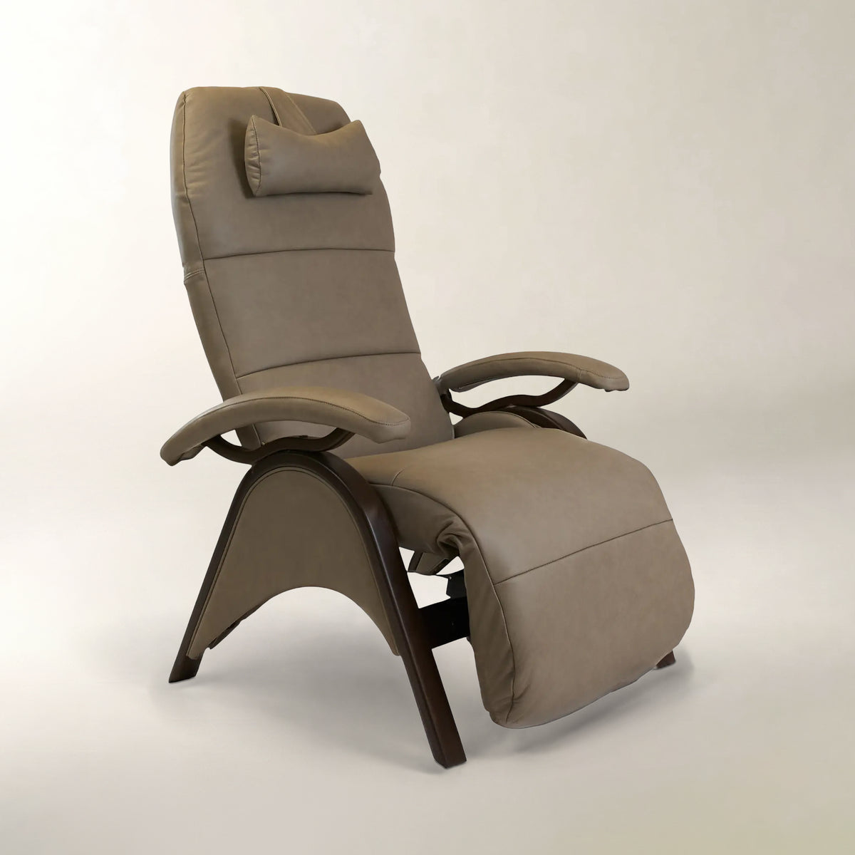 A modern high-back recliner chair with padded taupe-beige upholstery and a dark wood curved base, shown on a plain light gray studio background.