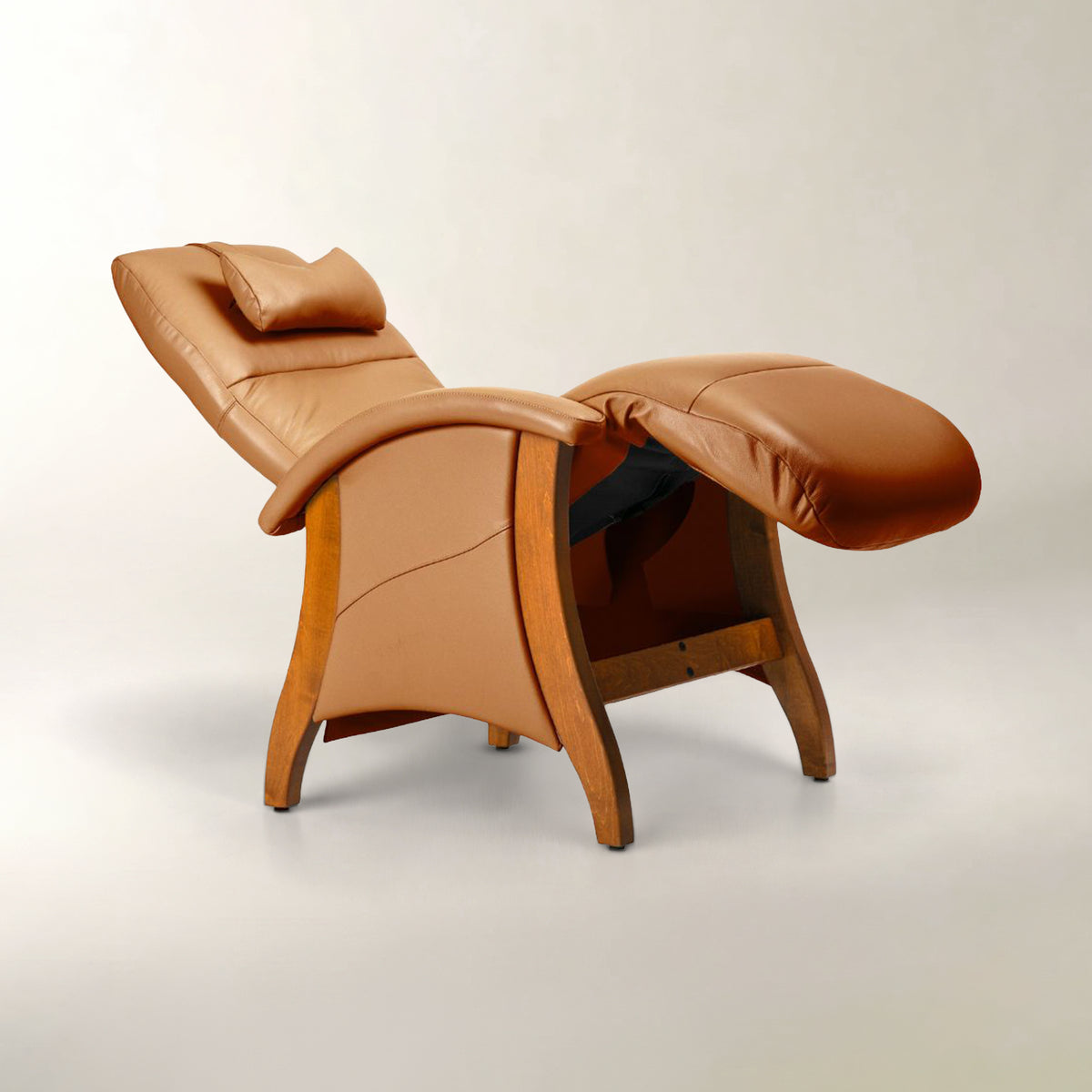 A tan leather recliner chair with a matching footrest and wooden frame, photographed on a neutral light gray studio background.