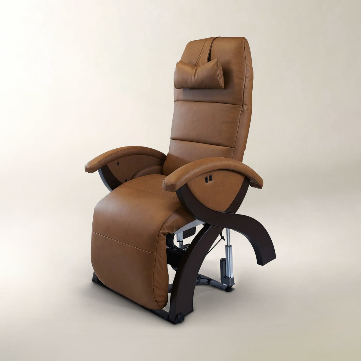 A brown leather recliner chair with a headrest pillow, padded armrests, and dark curved support arms, shown on a clean light beige studio background.