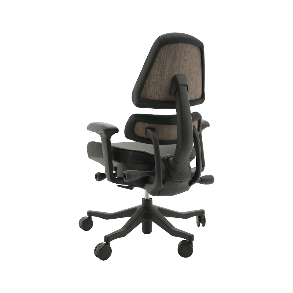 An ergonomic office chair with a high back, adjustable armrests, and a four-wheel base, shown from a rear angle on a white background.