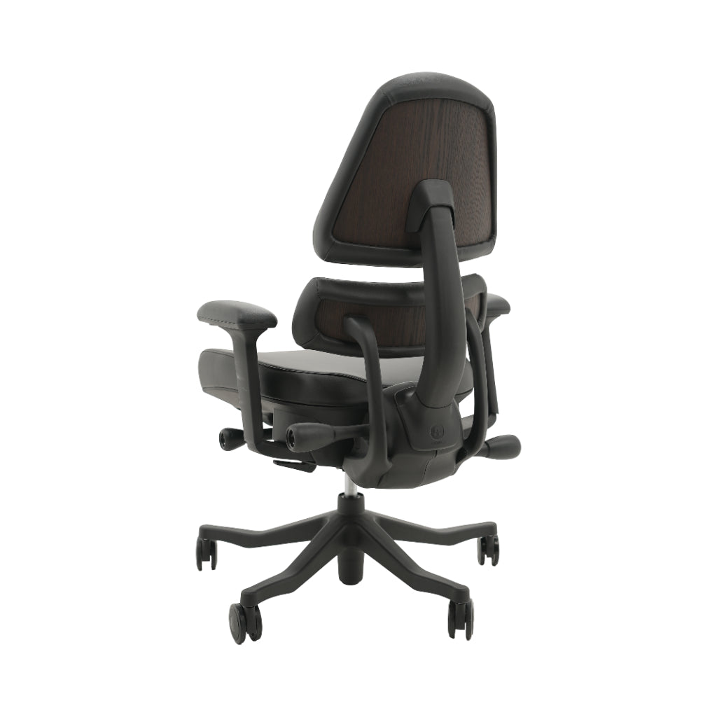 An ergonomic office chair with a high back, adjustable armrests, and a four-wheel base, shown from a rear angle on a white background.