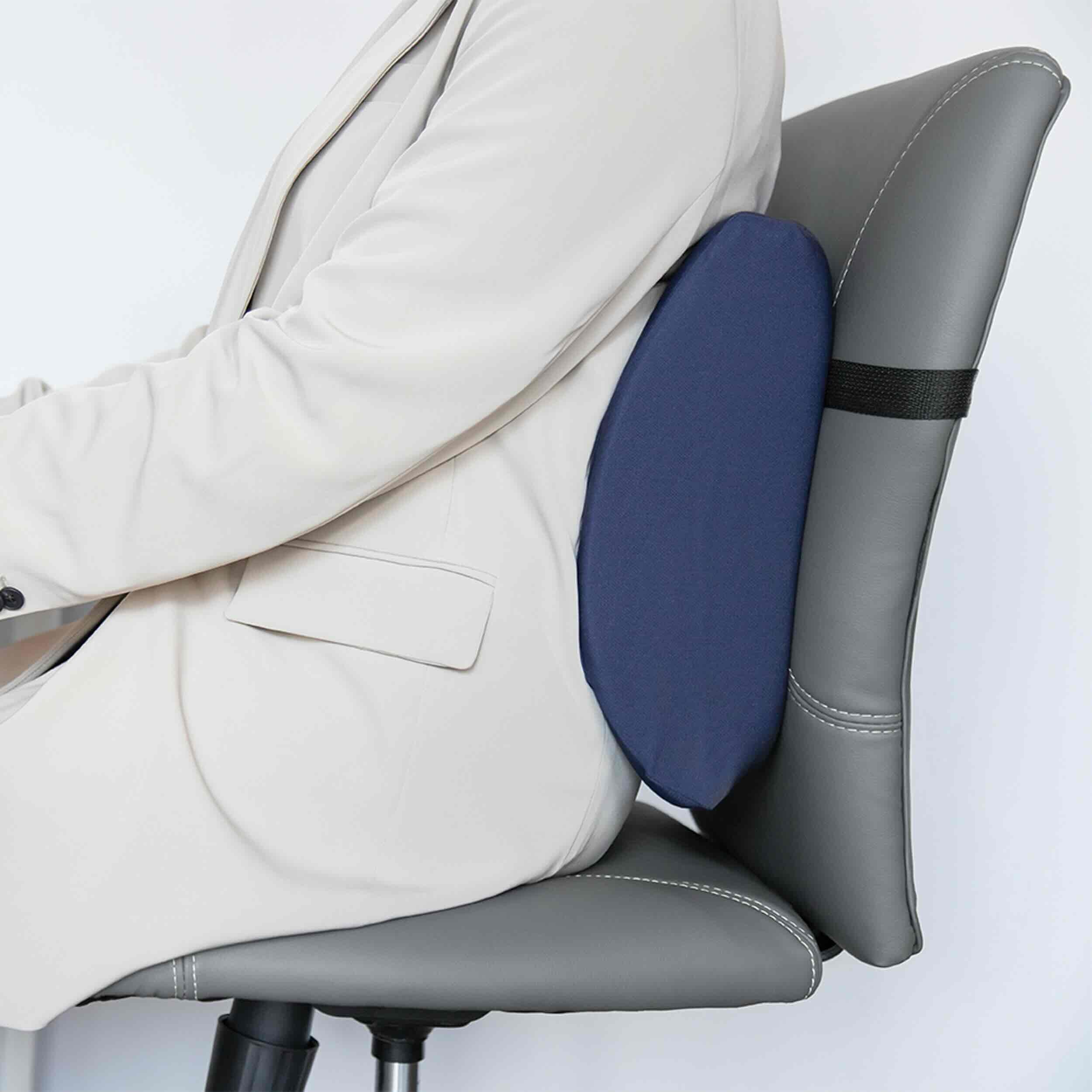 A navy blue lumbar support cushion attached to a gray office chair, shown with a person in a light beige blazer leaning forward to demonstrate use.