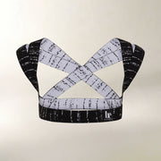 A black and white patterned posture support with crisscrossing straps, displayed against a light beige background.