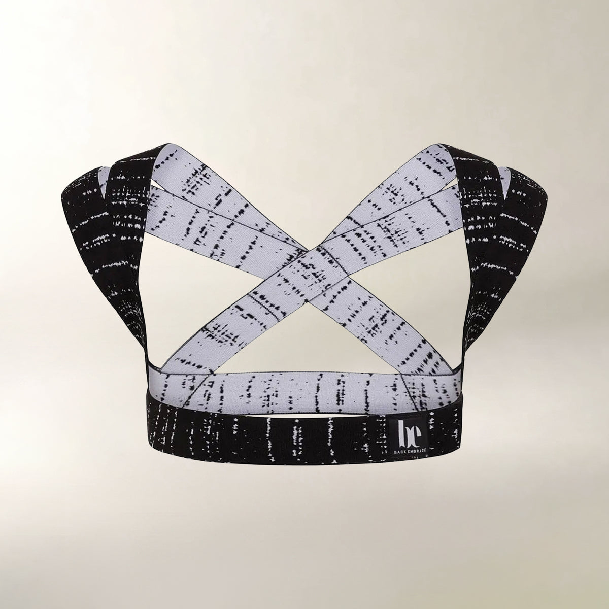 A black and white patterned posture support with crisscrossing straps, displayed against a light beige background.