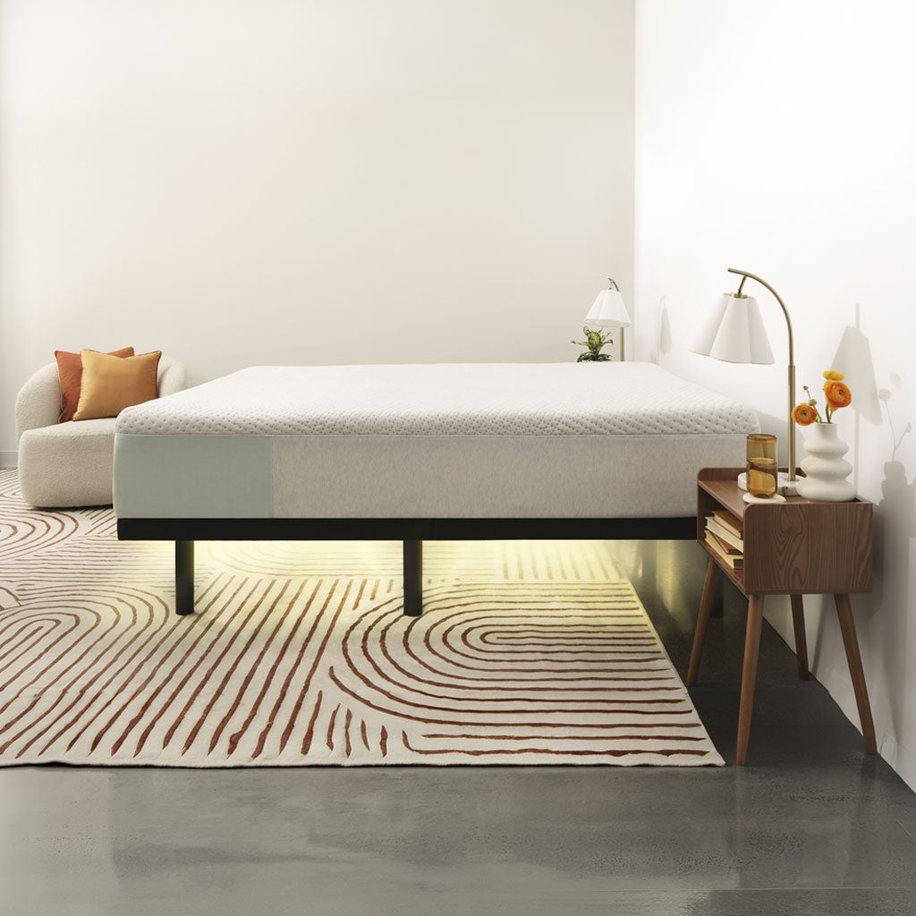 Modern bedroom with a bed, side table, and decorative items.