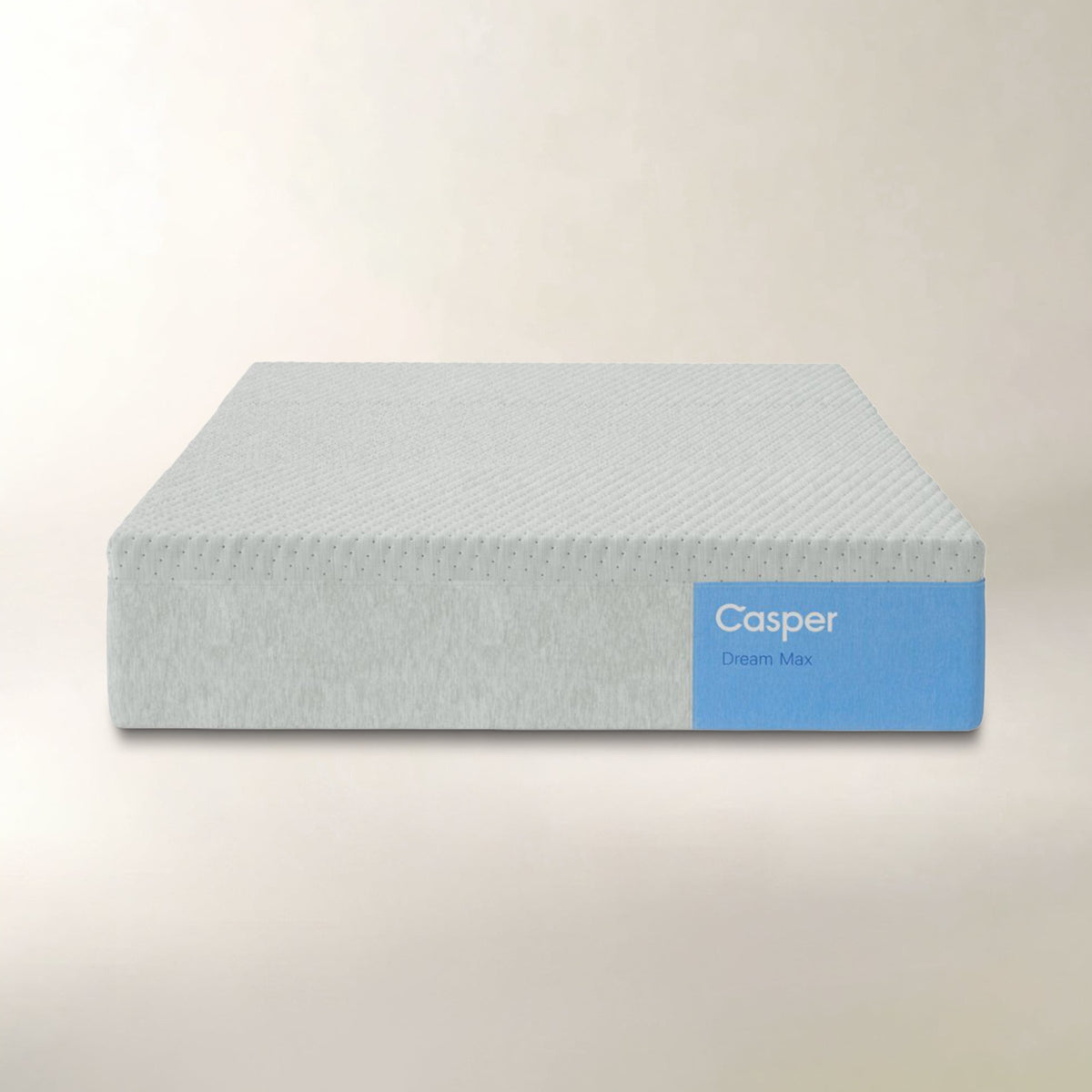 A Casper Dream Max mattress shown from a front angle against a neutral, light beige background. The mattress has a textured, light gray-blue top surface and a solid light blue side label with the white Casper brand name.