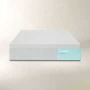 A Casper Snow Max mattress shown from a front angle against a warm beige background. The mattress features a textured white top surface and a light blue label on the side displaying the 'Casper Snow Max' branding.