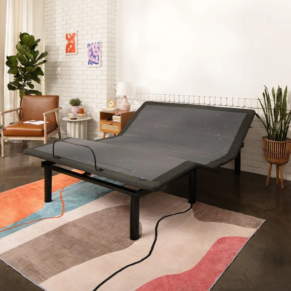 Adjustable base in a room with a rug, chair, and plants