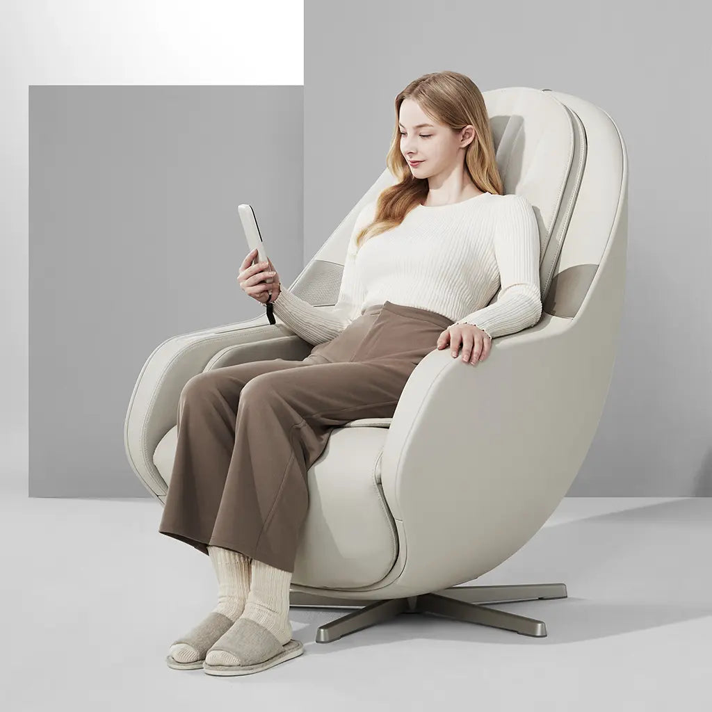 Woman sitting in a modern white massage chair using the chair's remote.