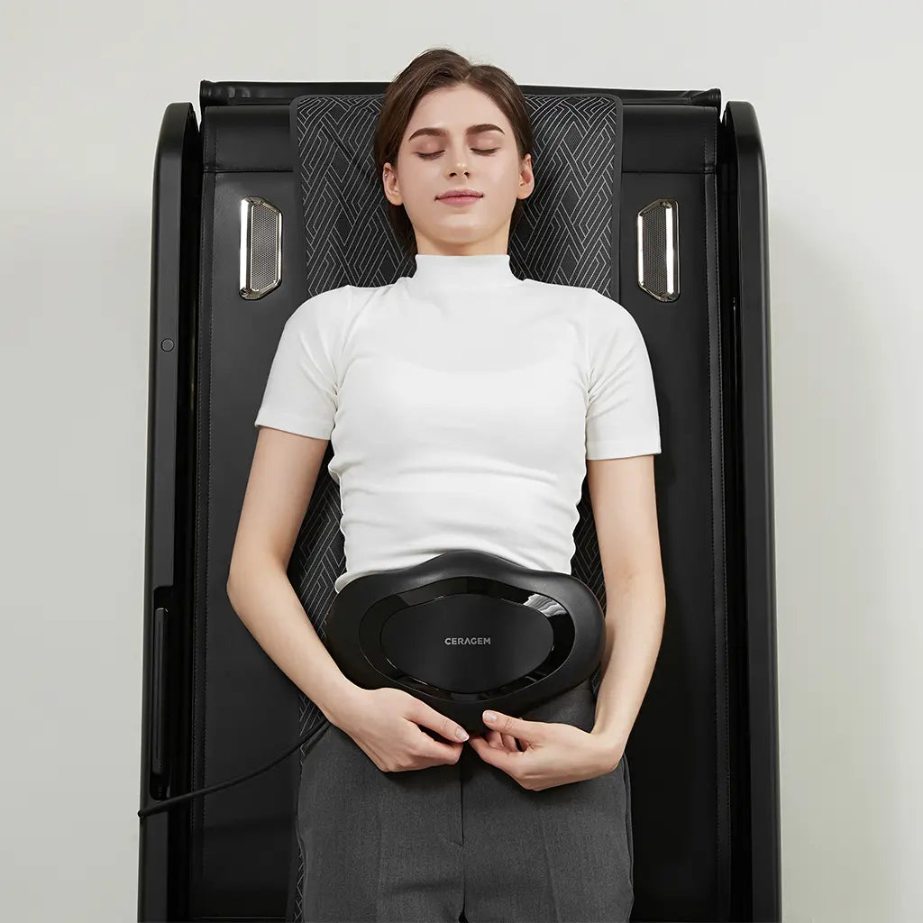 Woman using a massage bed with a neutral background.