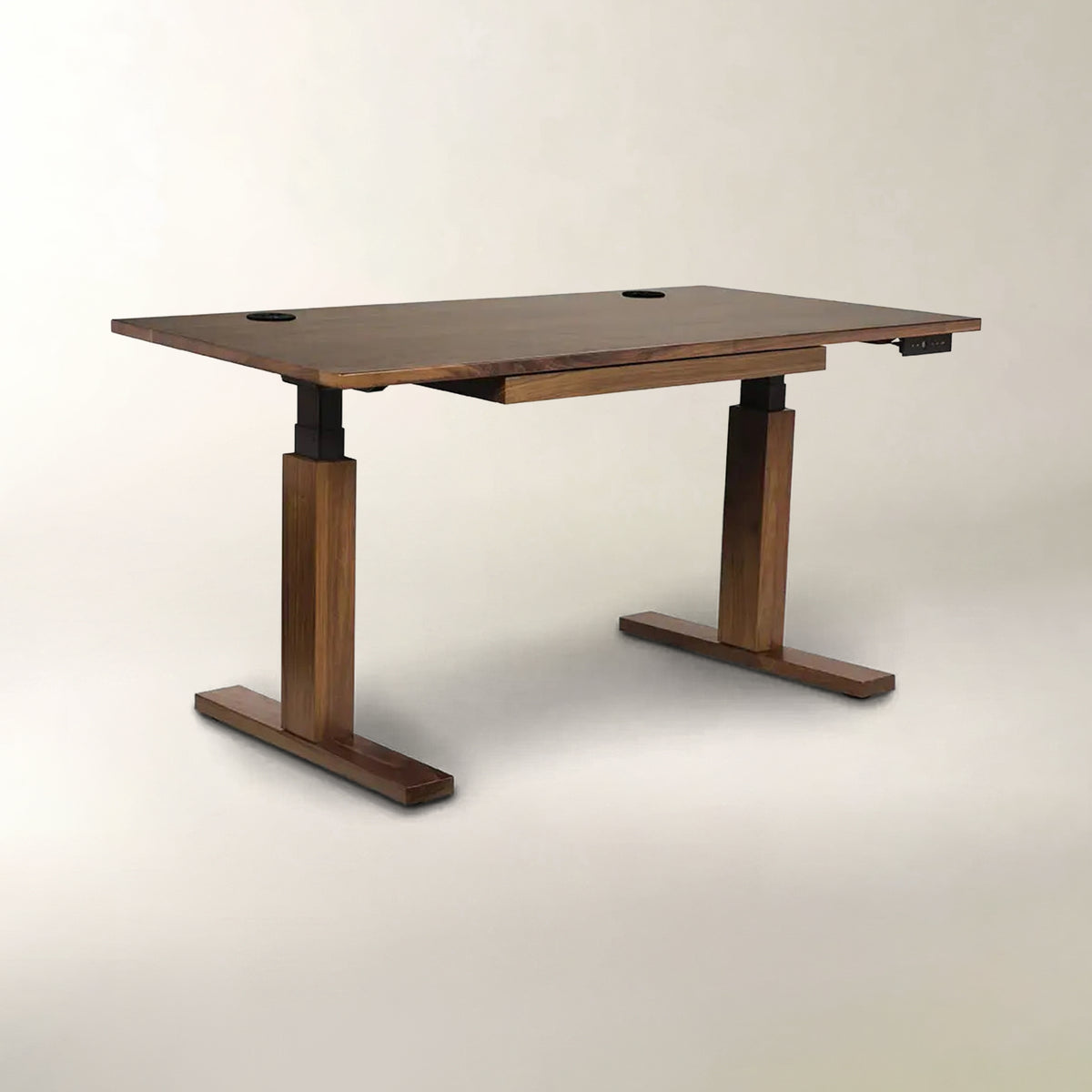 A modern adjustable height standing desk with a dark brown wood grain finish, featuring T-style legs and circular cutouts on the desktop, shown against a neutral light beige background.