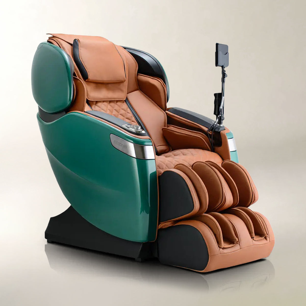 A luxury massage chair with a glossy teal green outer shell and tan-brown quilted leather interior, featuring a foot massager attachment and a phone mount arm, set against a neutral beige background.