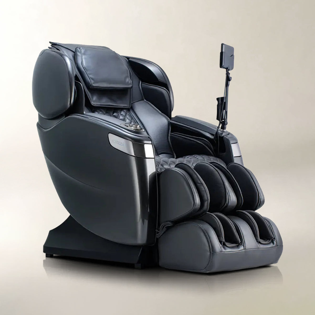 A modern black massage chair with multiple massage modes, a headrest pillow, and an adjustable armrest holding a phone, shown on a neutral beige background.