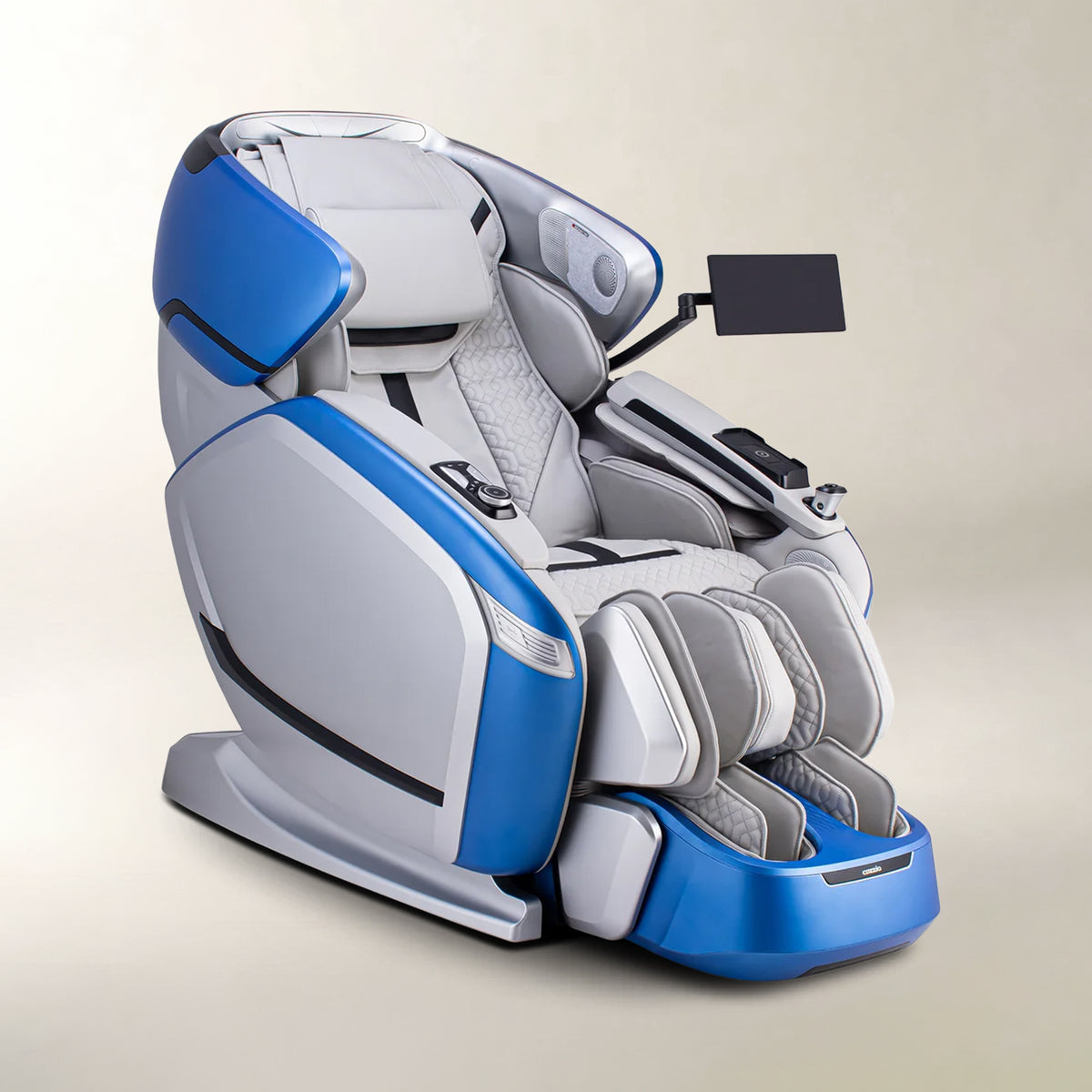 A modern multi-functional massage chair in blue and gray, featuring a padded headrest, lumbar support, foot rest, and an attached arm-mounted screen, set against a neutral beige background.