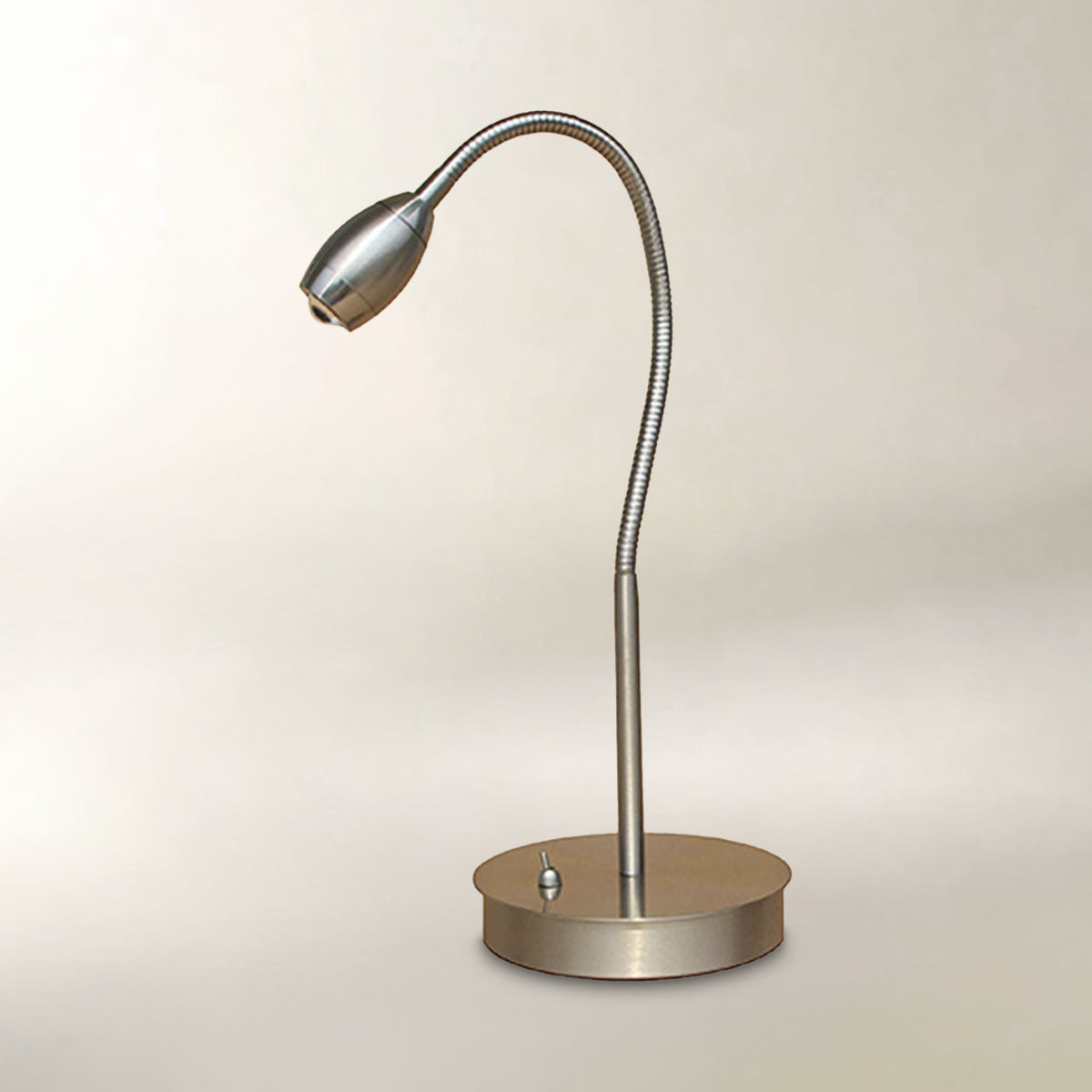 A modern adjustable desk lamp with a flexible gooseneck arm and a round base, finished in a brushed silver metal.