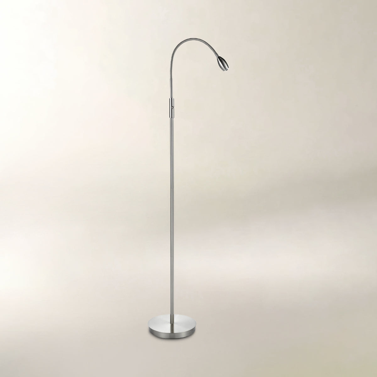A modern floor lamp with a slim, curved metallic arm and a circular base, shown against a plain, warm beige background.