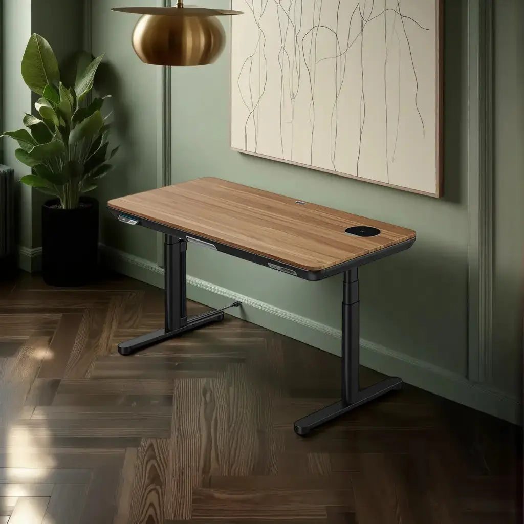 A modern walnut standing desk with a sleek glass surface sits in a sunlit room with sage paneling and a large plant in the corner.