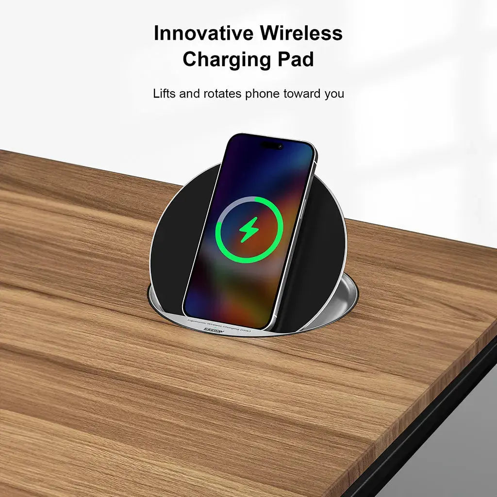 A phone sits on a round wireless charging pad embedded in a black desk, with charging in progress.