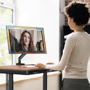 Person using a computer in a bright room with large windows